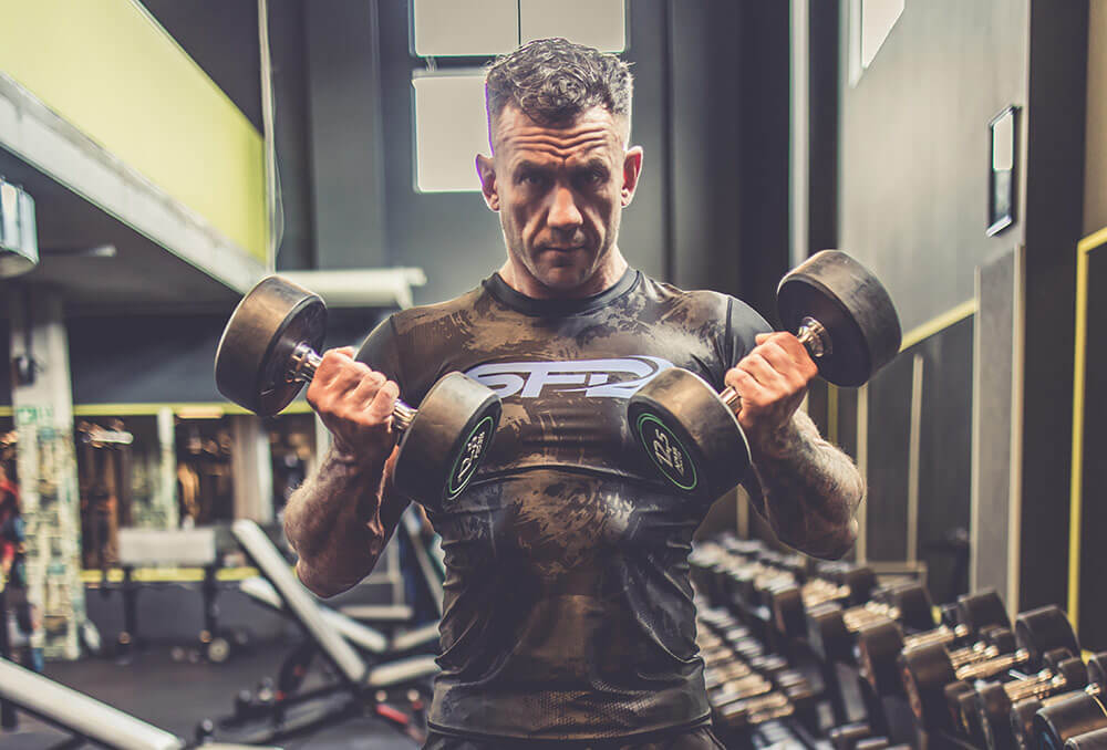 om cu gantere la sala de sport 