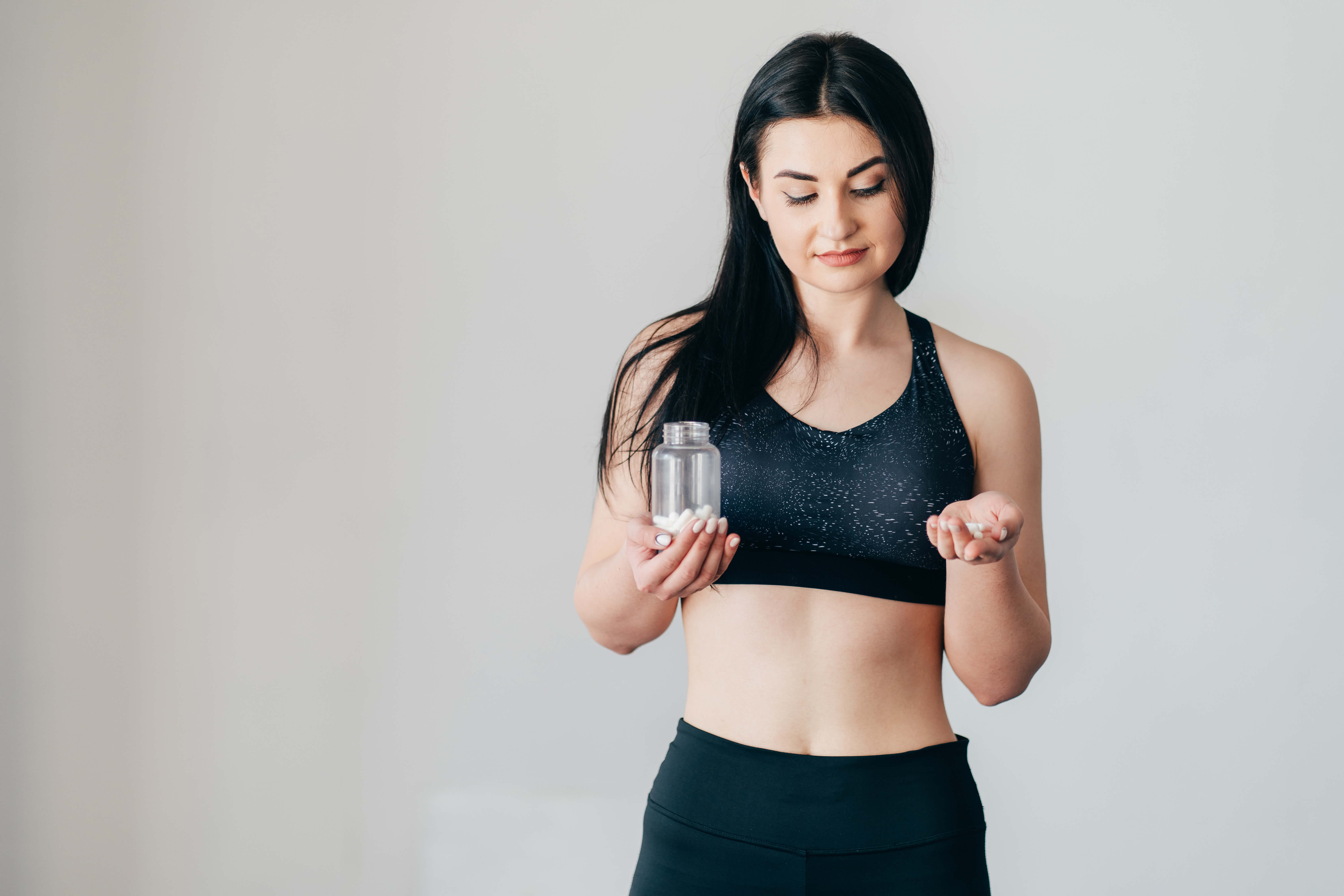 femeie cu o capsulă - supliment alimentar 