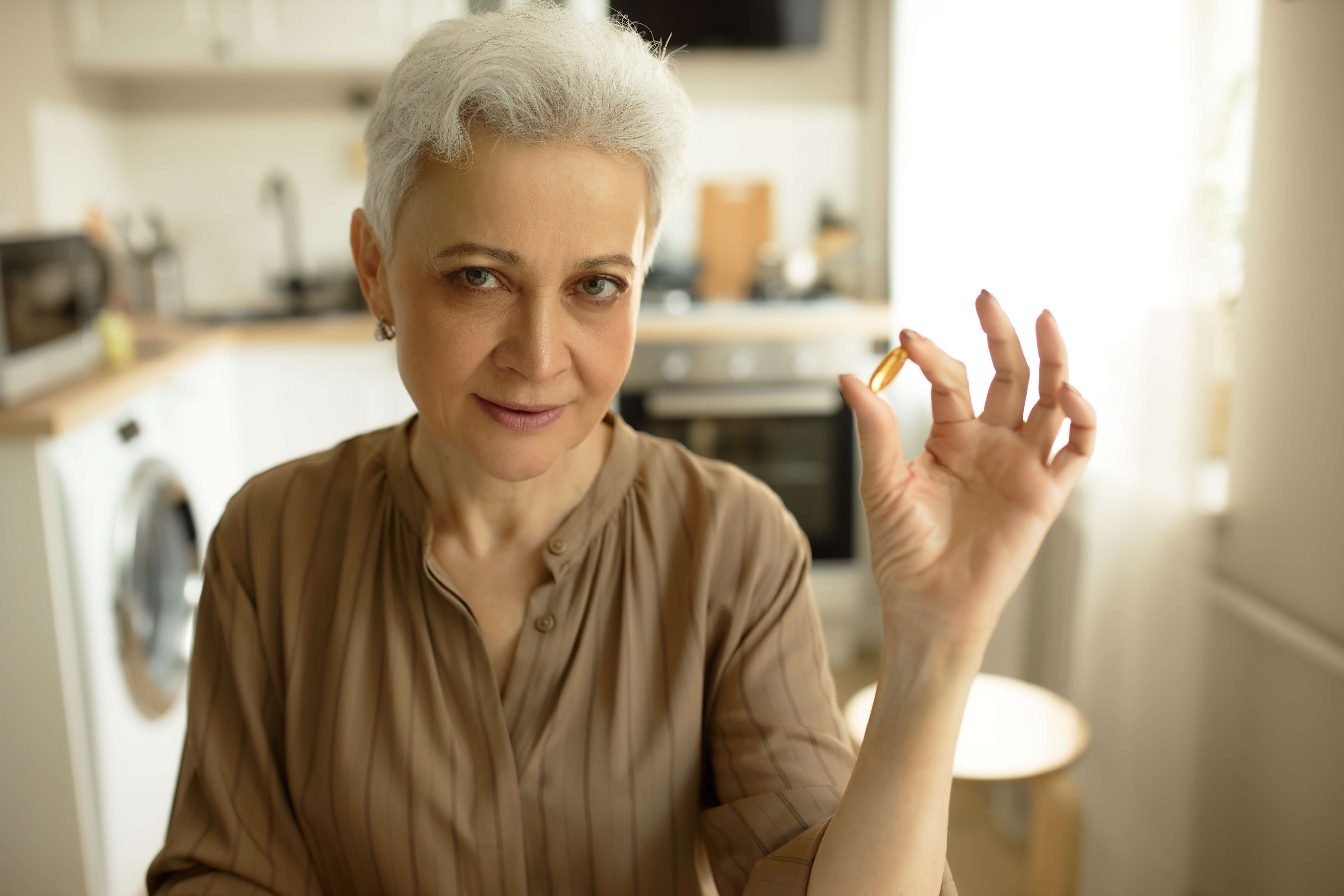 femeie în vârstă, omega 3 capsule 