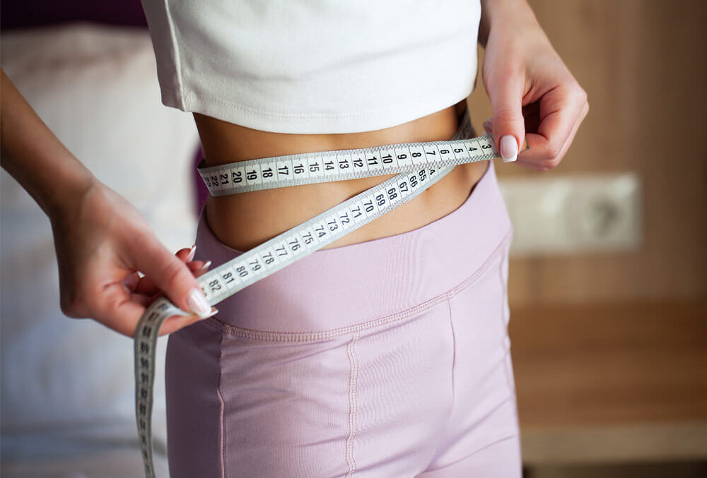 pierderea în greutate - o femeie cu o bandă de măsurare 