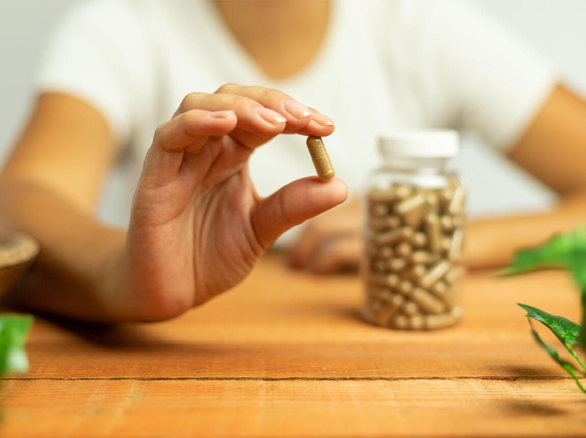 femeie cu capsulă de ashwagandha