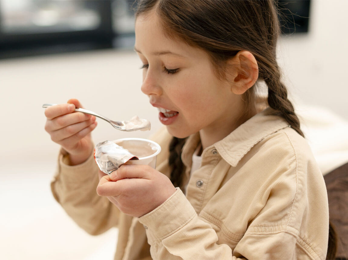 fetiță cu iaurt - probiotice pentru copii