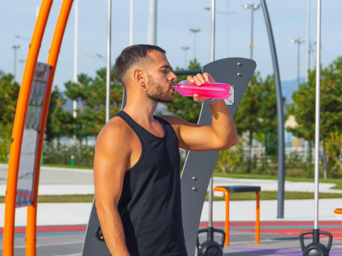 un bărbat cu o sticlă de electroliti într-o zi toridă